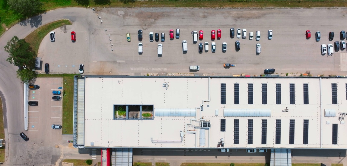 Ein großer Gewerbepark inkl. Parkplatz aus der Vogelperspektive.